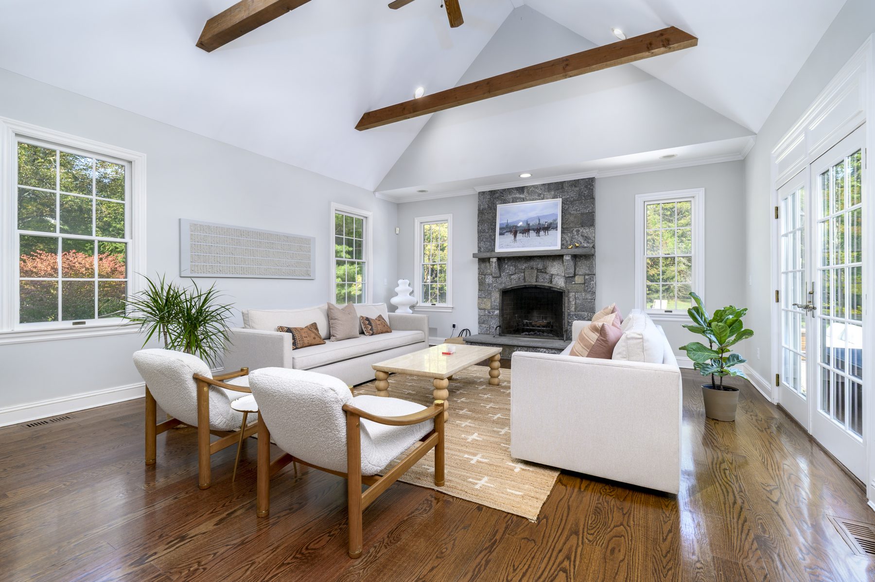 Vaulted great room with stone fireplace and beamed ceiling
