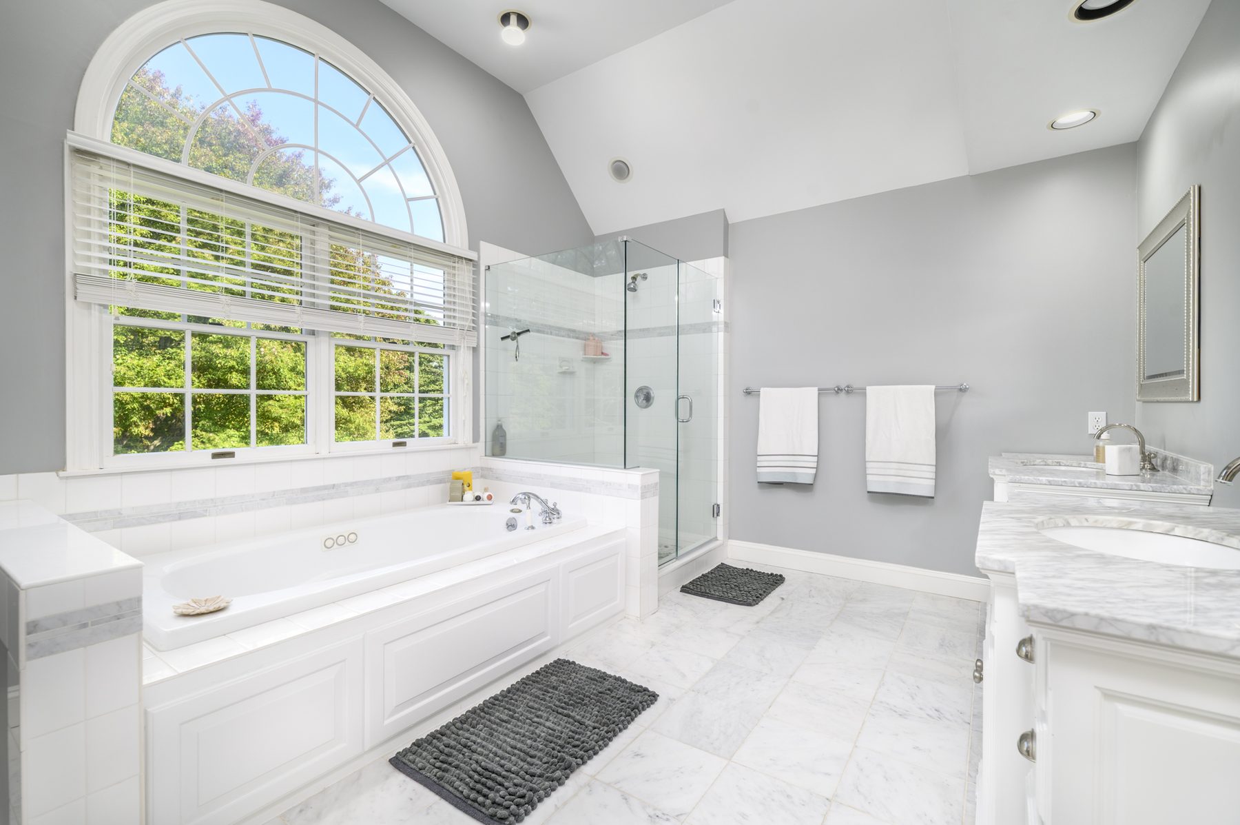 Primary bathroom with arched window and soaking tub