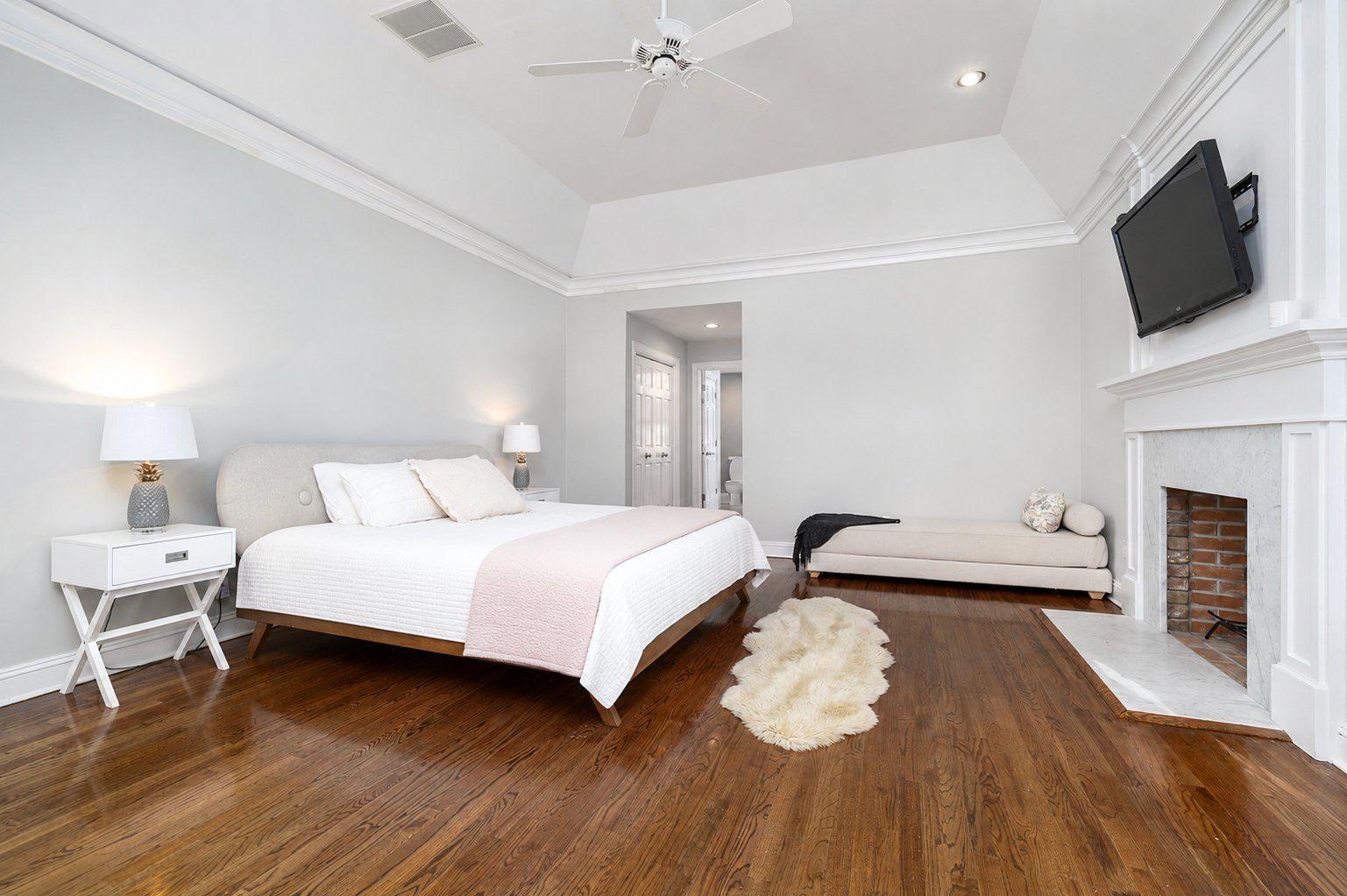 Primary bedroom with vaulted ceiling and fireplace