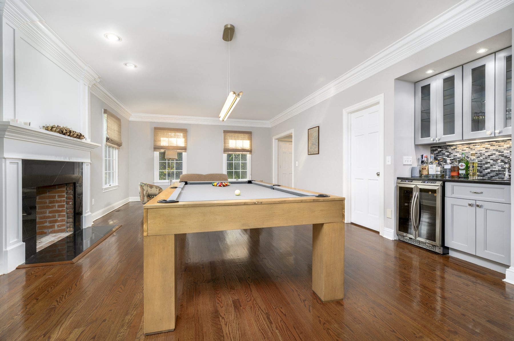 Pool table room with full-size pool table and stone fireplace